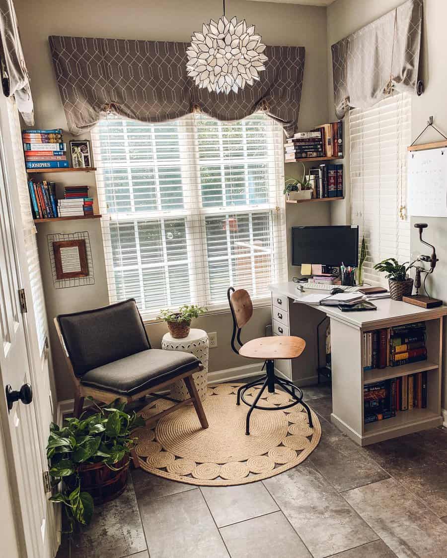 Cozy home office with a desk, chair, computer, bookshelves, plants, and a circular rug; large window with curtains and pendant light