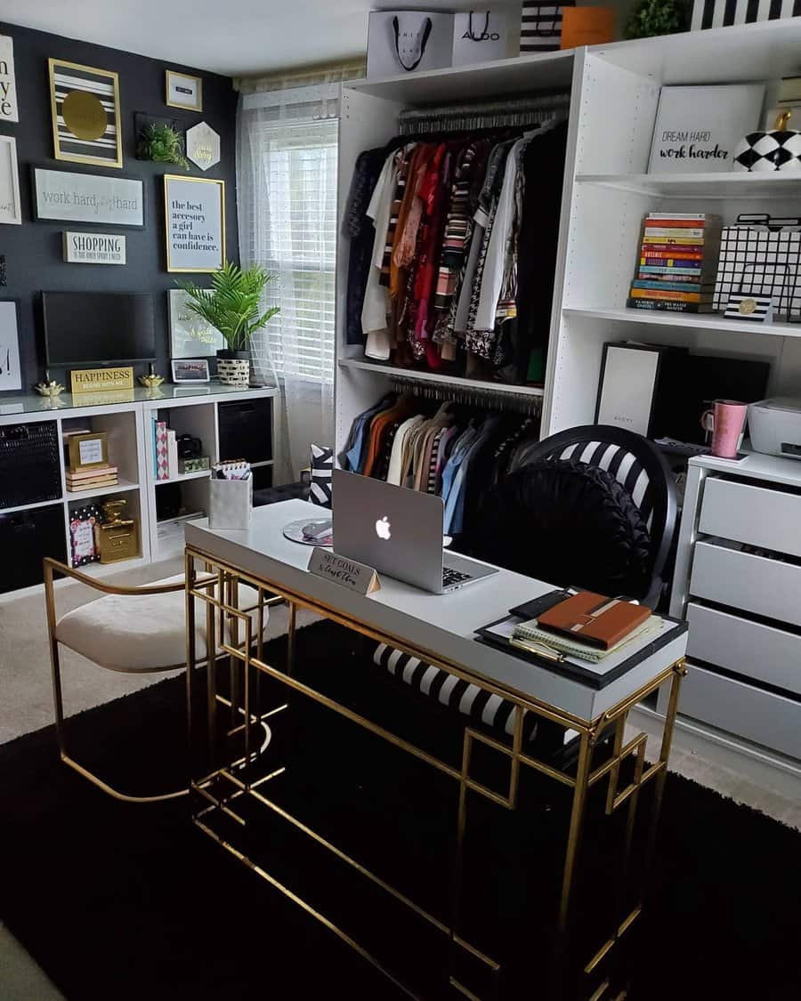 Chic home office with a gold-accented desk, laptop, books, striped chair, and closet full of clothes; walls adorned with framed quotes