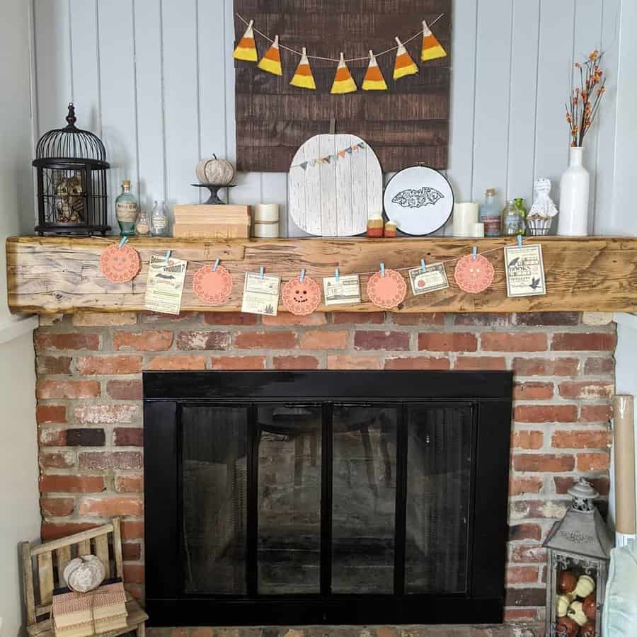 A decorated brick fireplace with autumn and Halloween-themed decor