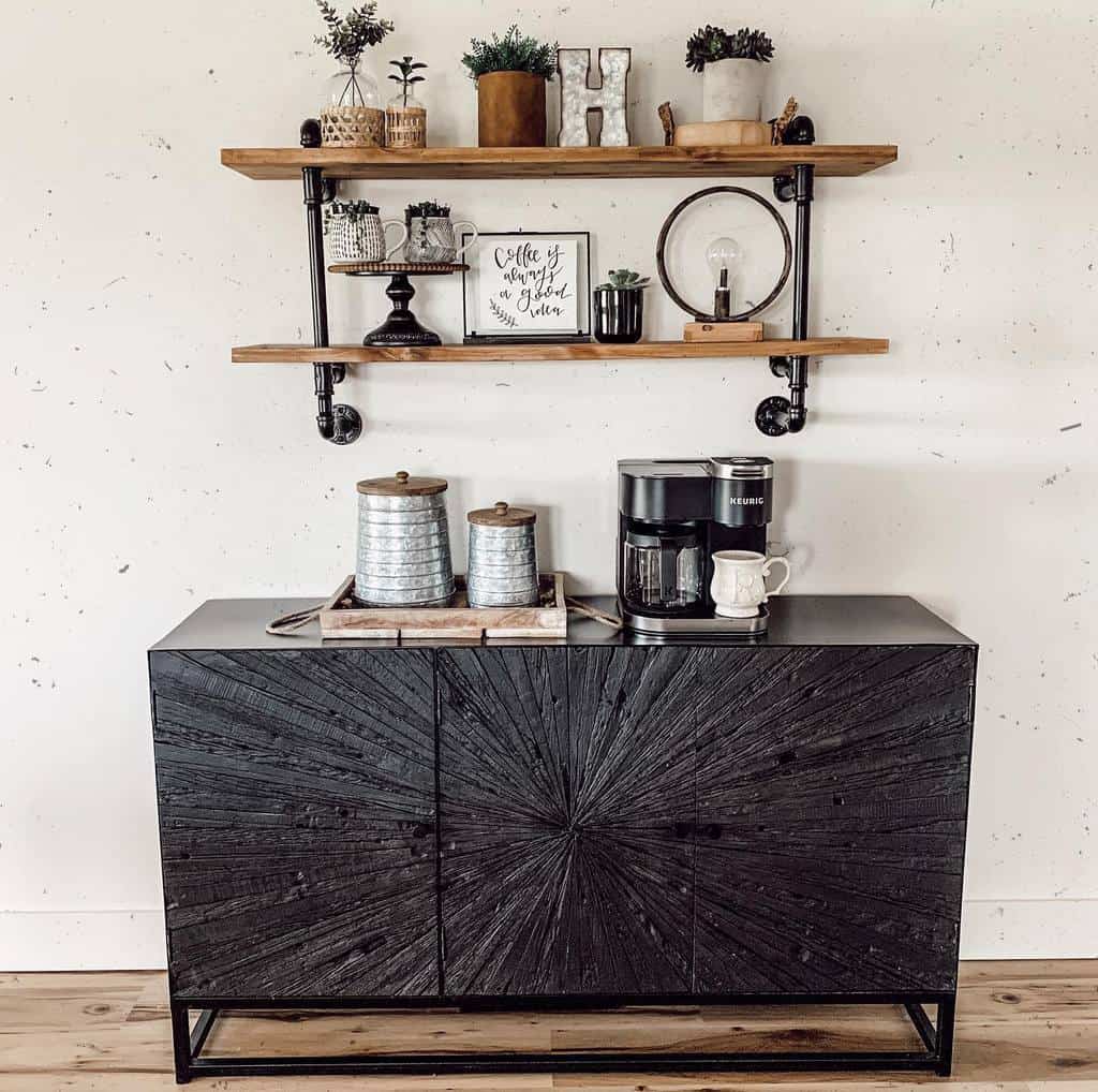 Industrial-style floating shelves with metal pipe brackets above a black sideboard, styled with plants, coffee decor, and rustic accents