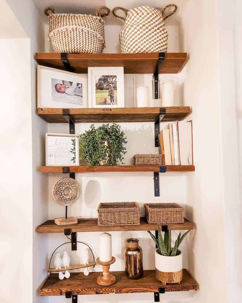 Wooden shelves with woven baskets, framed photos, candles, a small plant, and decorative items neatly arranged in a cozy display