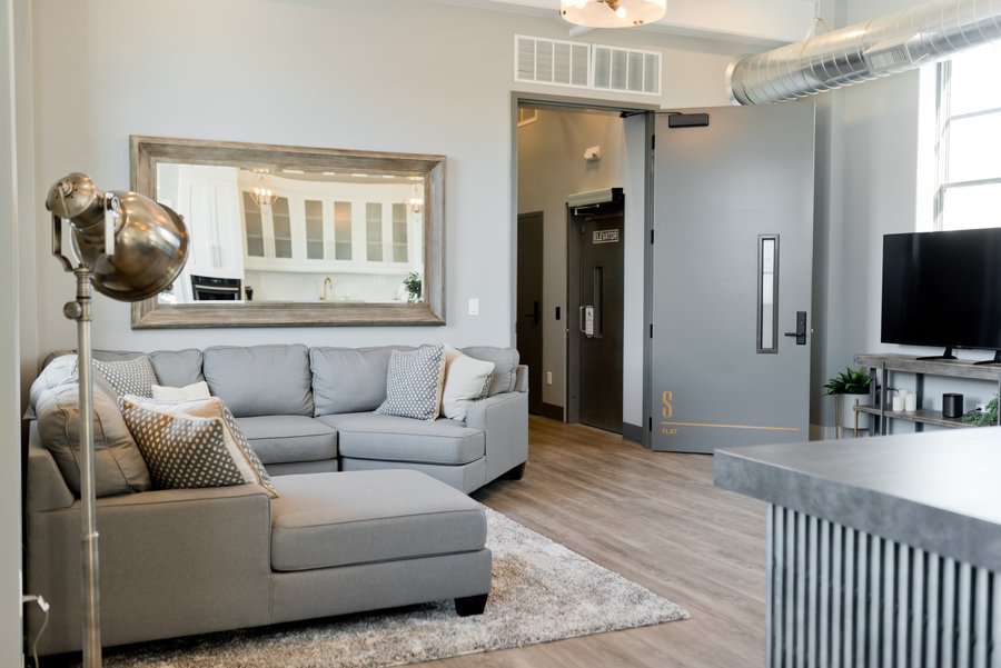 Loft style living room with exposed ductwork and mirror