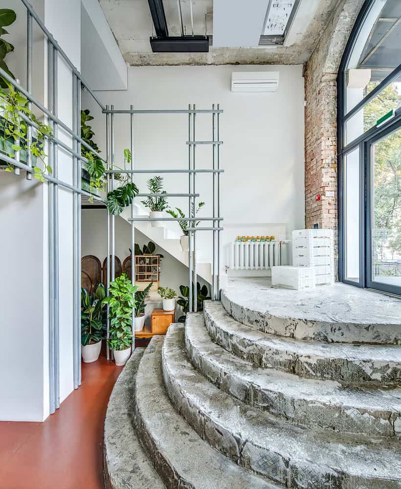 Loft with spiral staircase and lush green plants