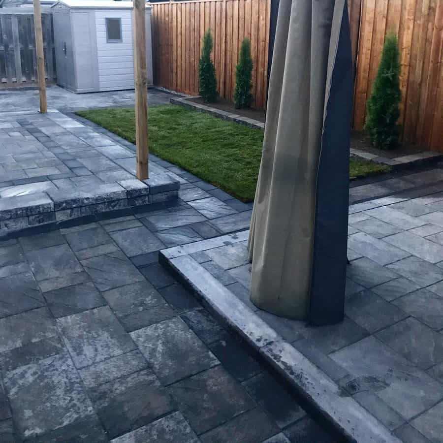 Modern patio with interlocking stones and landscaped yard