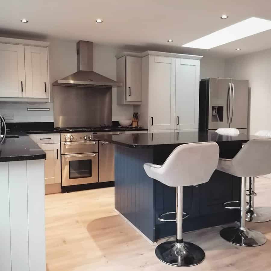 Modern kitchen with navy island and bar stools