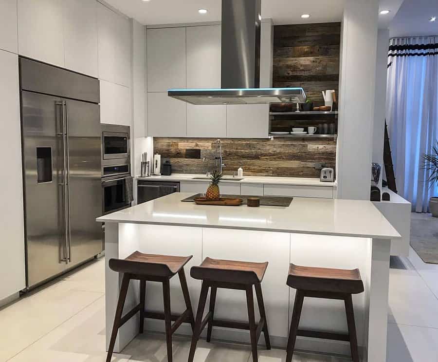 Modern kitchen with island, barstools, stainless steel appliances, and wood accents