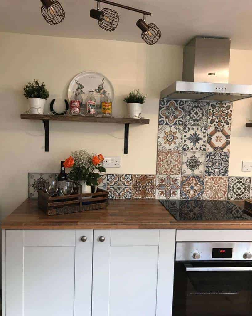 Rustic kitchen with a wooden floating shelf, decorative tile backsplash, potted plants, and vintage-inspired decor above a wooden countertop