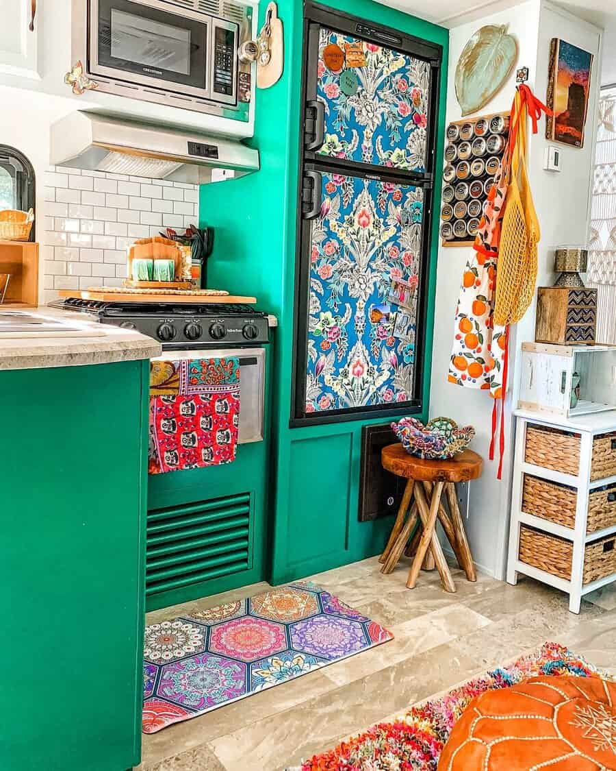 Vibrant RV kitchen with bold green cabinetry, a floral-patterned fridge, a spice rack, and colorful decor for a lively, eclectic feel.