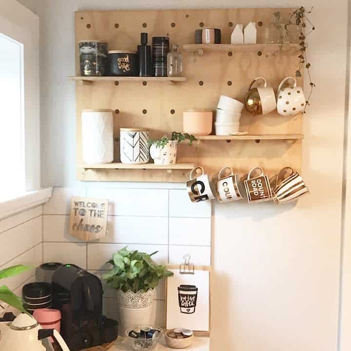 Kitchen corner with pegboard shelves holding mugs, jars, and decor