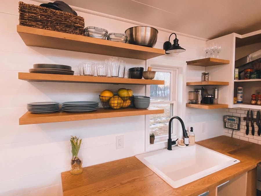 Open kitchen shelving with dishes and sink in a tiny home