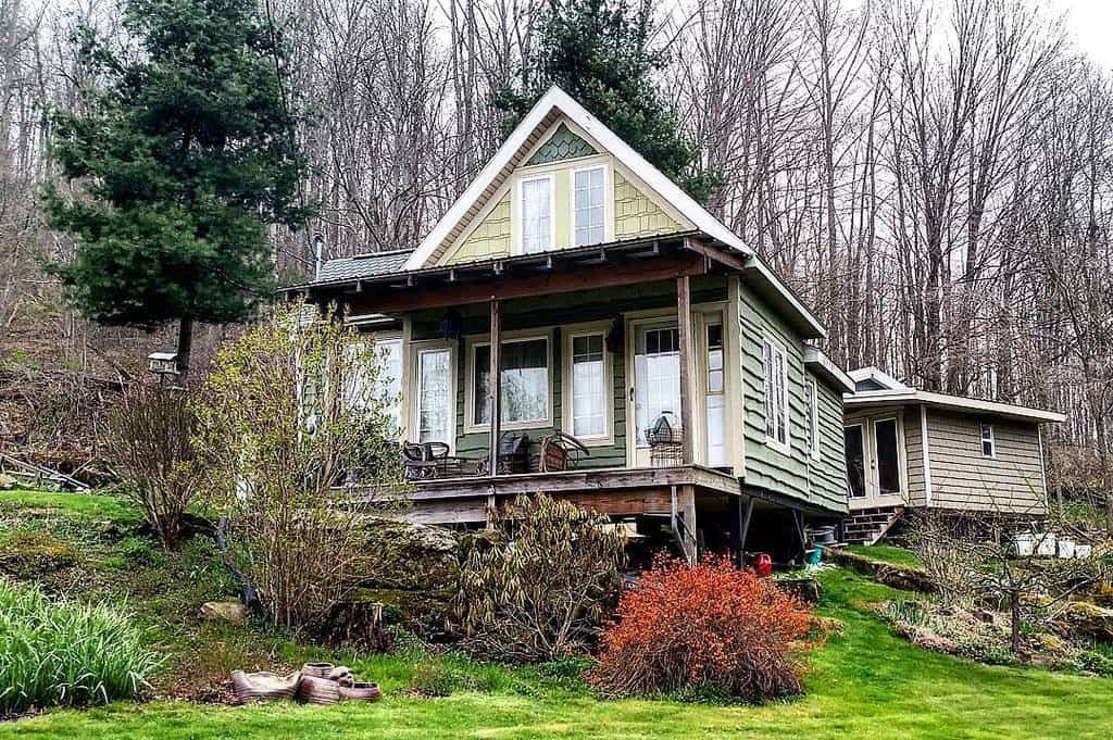 A charming wooden house with a porch in a wooded area