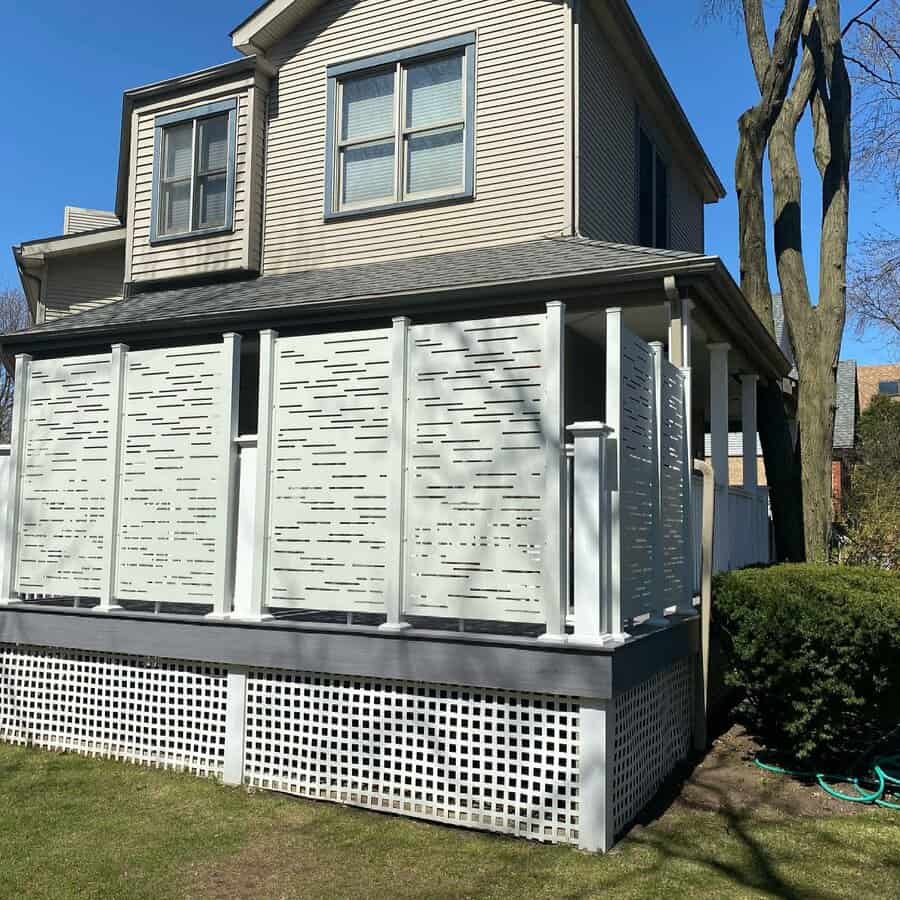 House with a deck featuring white lattice and slat skirting