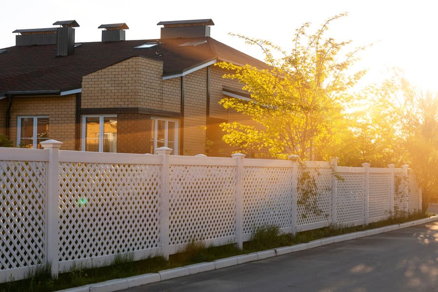 Lattice fence at sunset with brick house