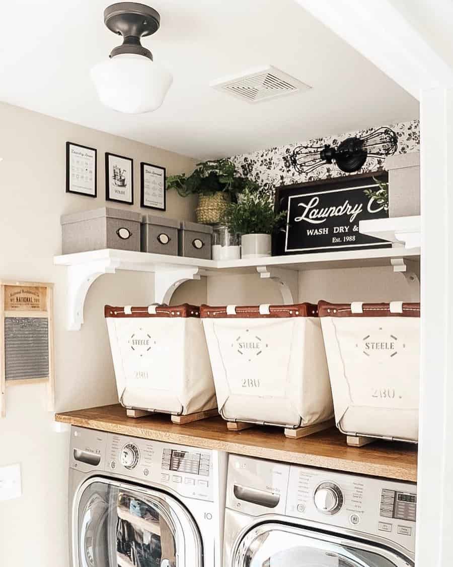 A compact laundry room with overhead shelves, labeled storage bins, and a wooden countertop over front-loading machines for an organized space