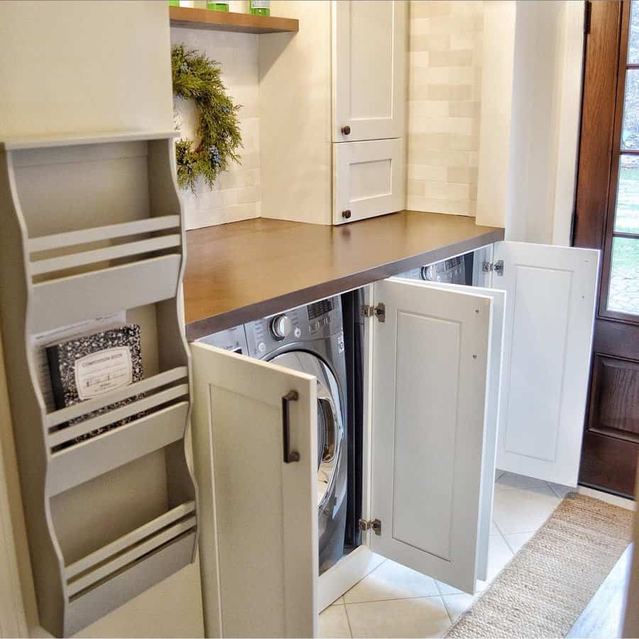 A stylish laundry space with hidden washer and dryer behind cabinet doors, wooden countertops, and overhead storage for a clean, functional look