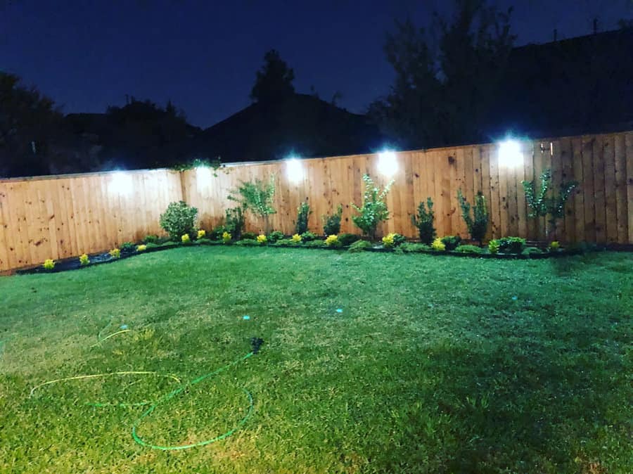 backyard landscaping with fence sconces