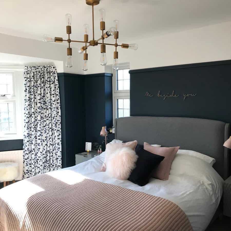 Chic bedroom with dark accent wall and modern chandelier