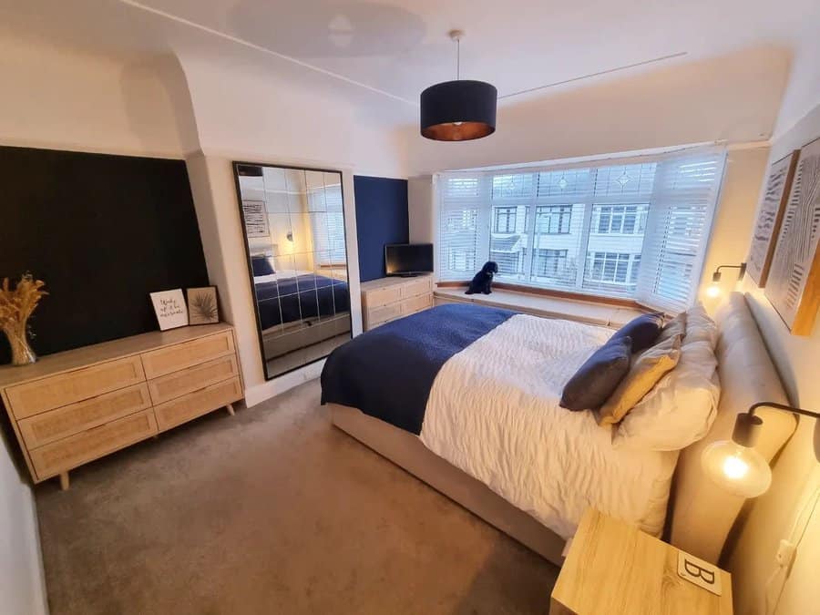 Spacious bedroom with large window and mirrored wardrobe