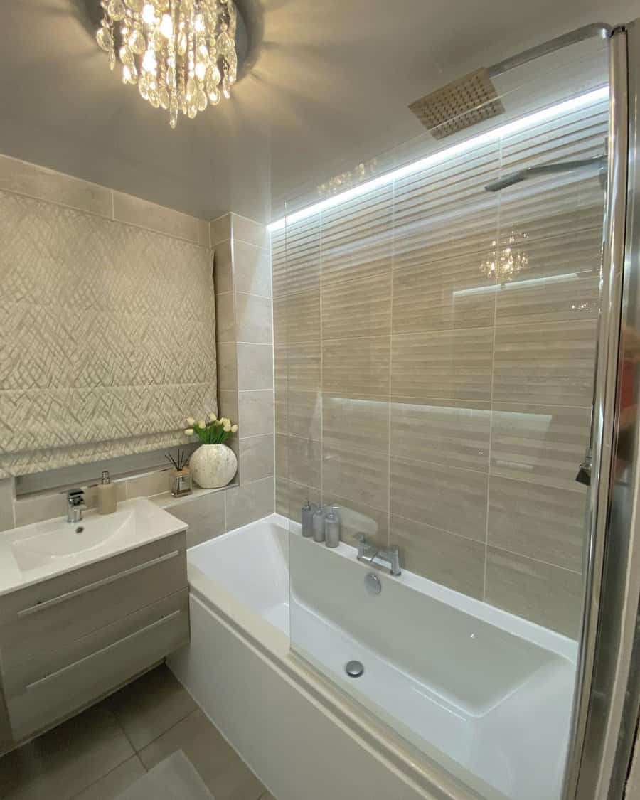 Luxury bathroom with chandelier and tiled walls