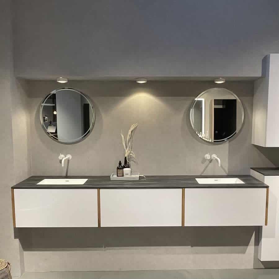 Minimalist double vanity with circular mirrors and wall lights