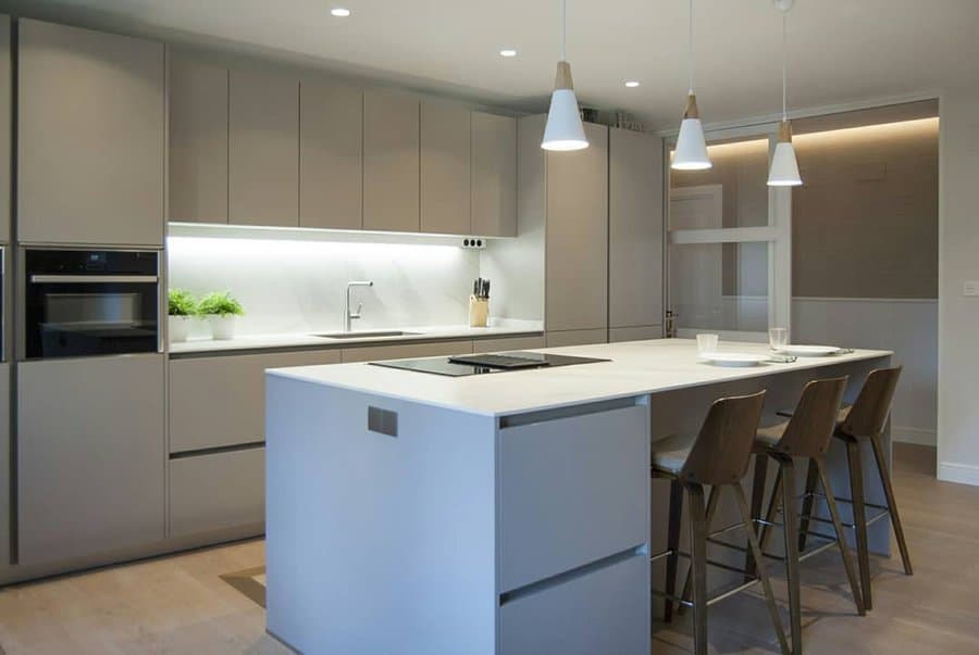 Modern kitchen with island, bar stools, hanging lights, and minimalist design