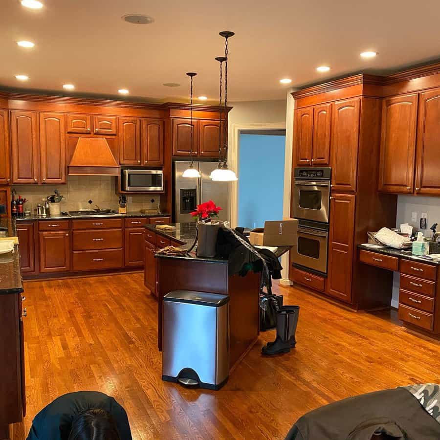 Spacious kitchen with wooden cabinets, island, and pendant lights