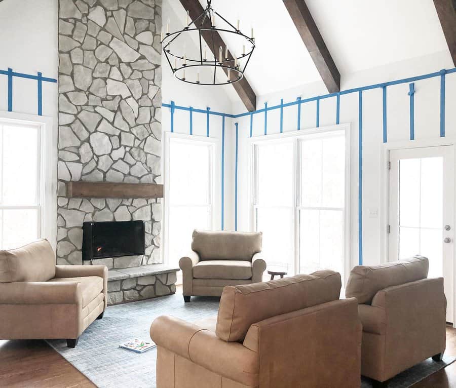 Spacious living room with stone fireplace and tan sofas