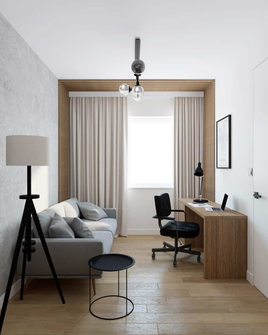 Minimalistic home office with a gray sofa, wooden desk, black chair, and floor lamp. Curtains frame a large window, illuminating the space