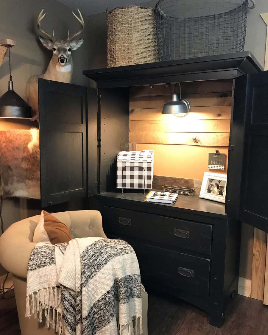 Cozy nook with an armchair, blanket, and cabinet desk; decor includes a deer mount, plaid file organizer, and a photo frame