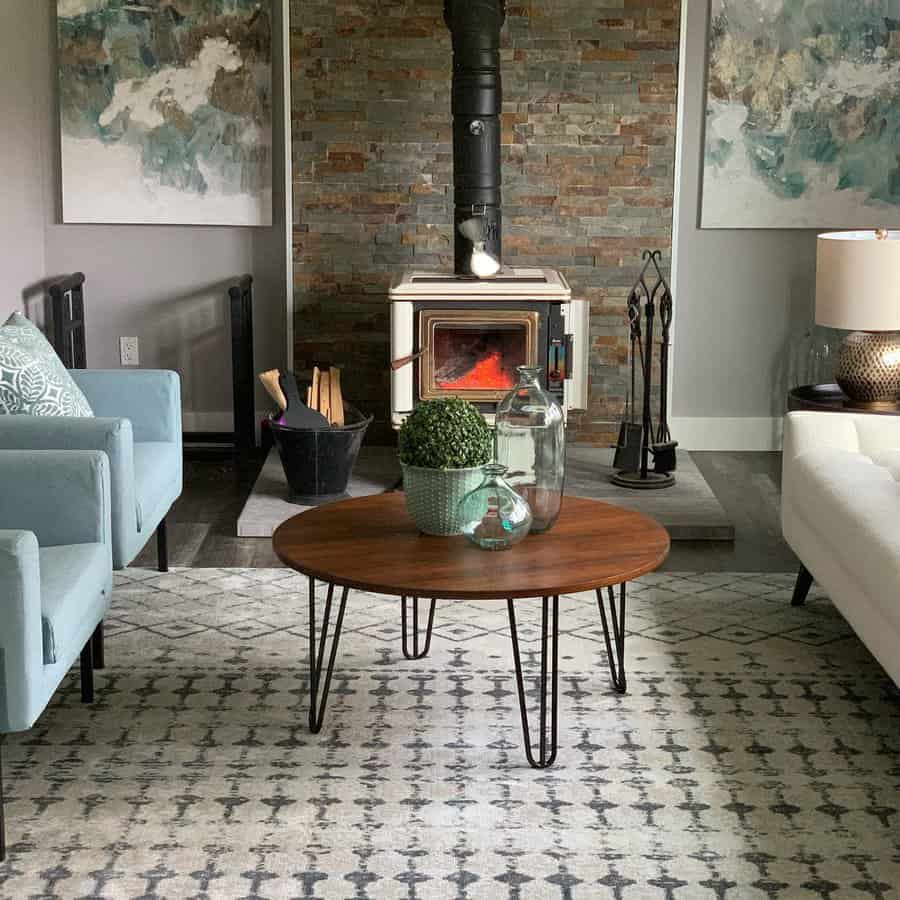 Modern living room with a cozy wood stove set against a stacked stone accent wall, complemented by soft pastel seating and stylish decor.