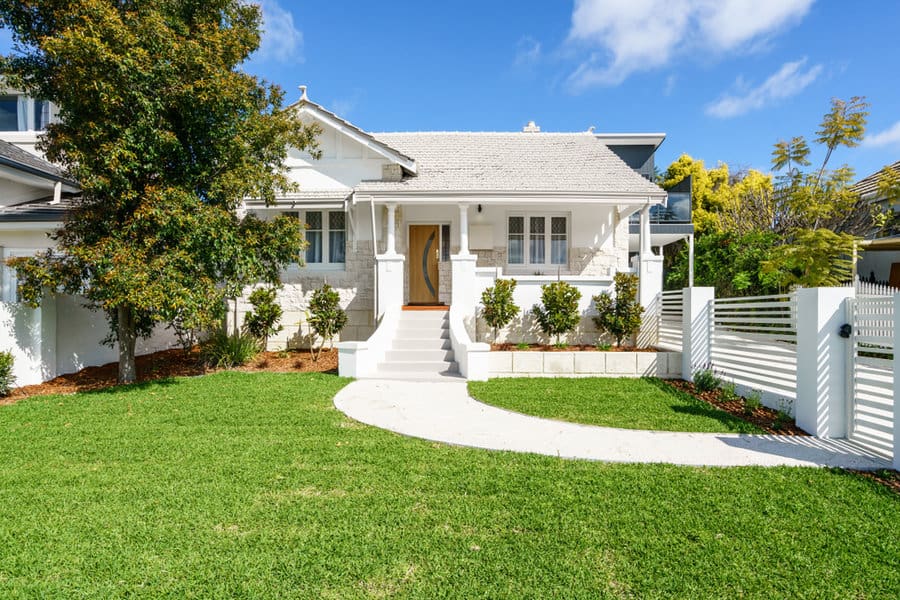 White house with winding walkway and fence