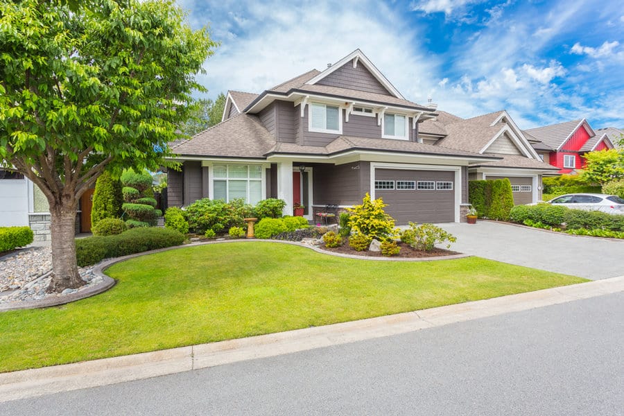 House with curved driveway and landscaped yard