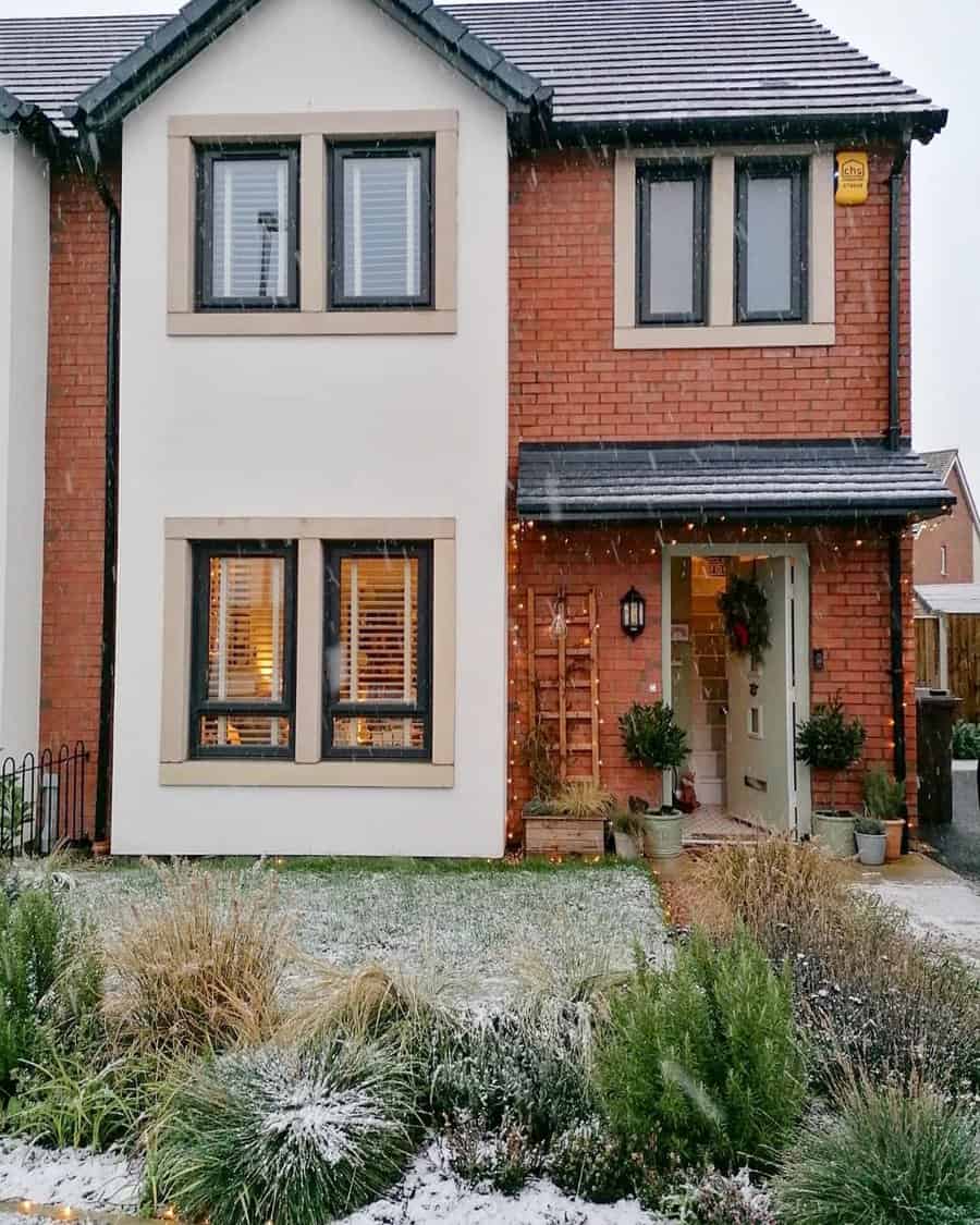 Two story house with snow-covered garden