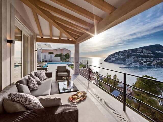 Luxury balcony with a stunning ocean view, elegant outdoor seating, and a wooden beam ceiling, creating a serene and sophisticated retreat