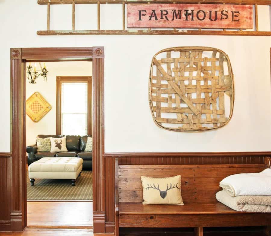 Rustic farmhouse entryway with a wooden bench, vintage ladder decor, woven wall art, and cozy textiles, creating a warm and inviting space