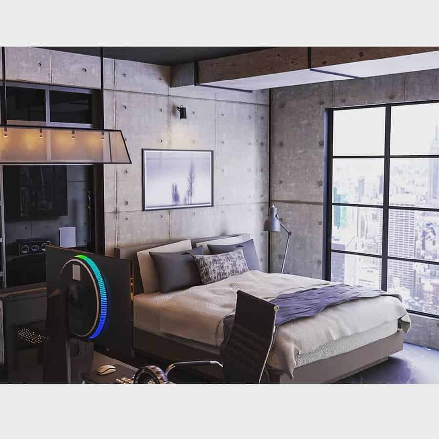 Modern industrial bedroom with a large bed, gaming setup, and floor-to-ceiling windows showing a cityscape; concrete walls add an industrial feel