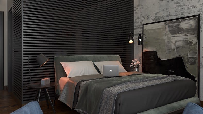 Modern bedroom with a gray bed, laptop, and side table with a lamp, black slatted wall, and abstract painting in the background