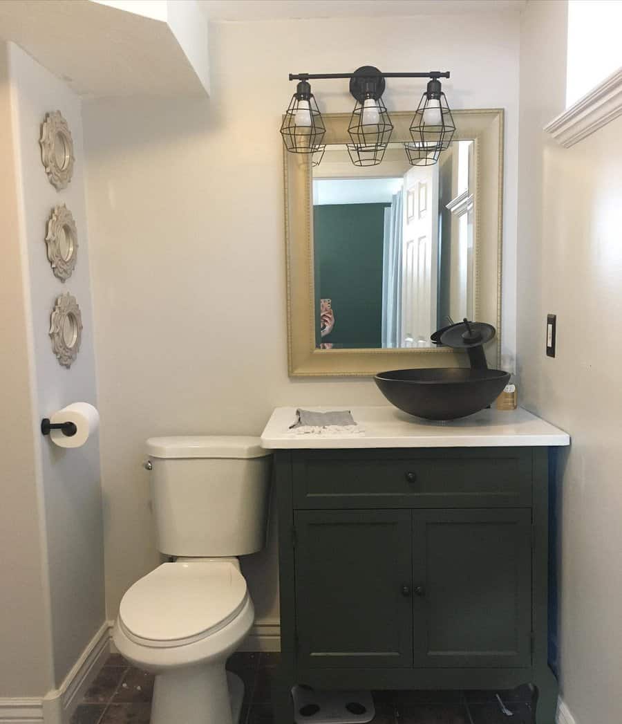 Vintage-style bathroom with green vanity and cage lights