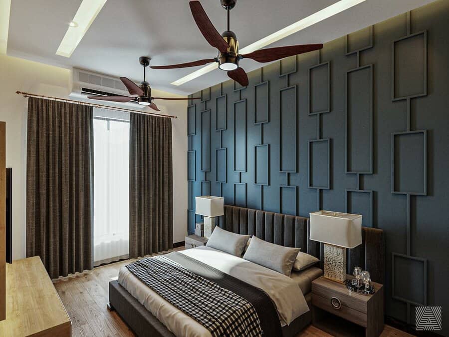 Modern master bedroom featuring a blue accent wall, double ceiling fans, and a large bed with window curtains and wooden furniture