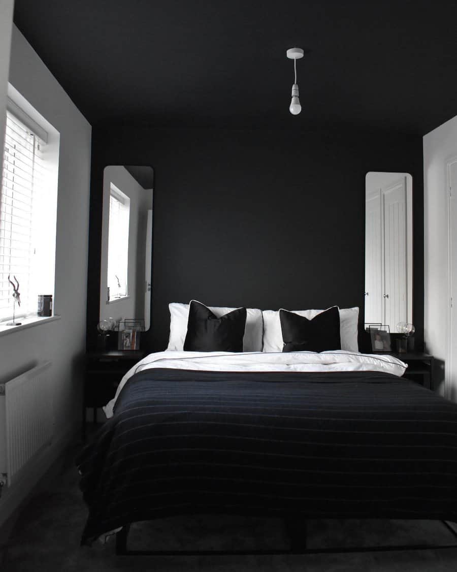 black bedroom with full-length mirrors