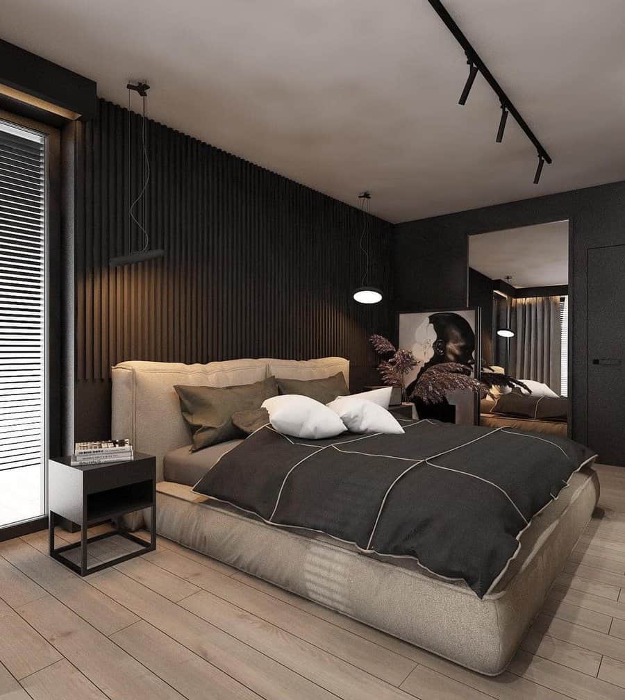 Modern black bedroom with a low beige bed, sleek lighting, slatted accent wall, and bold wall art for a chic, moody retreat