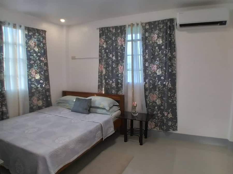 Simple bedroom with floral curtains and grey bedding