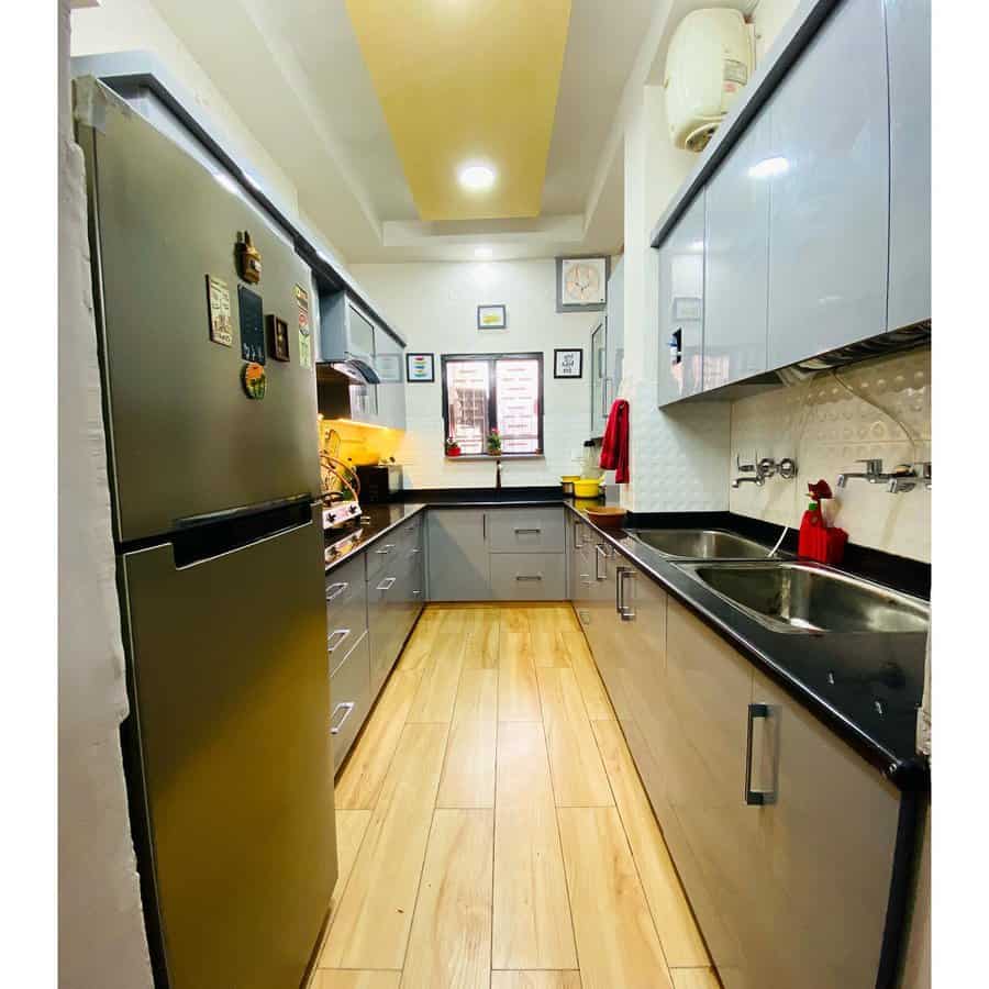 Narrow kitchen with dark cabinets and light wood floors