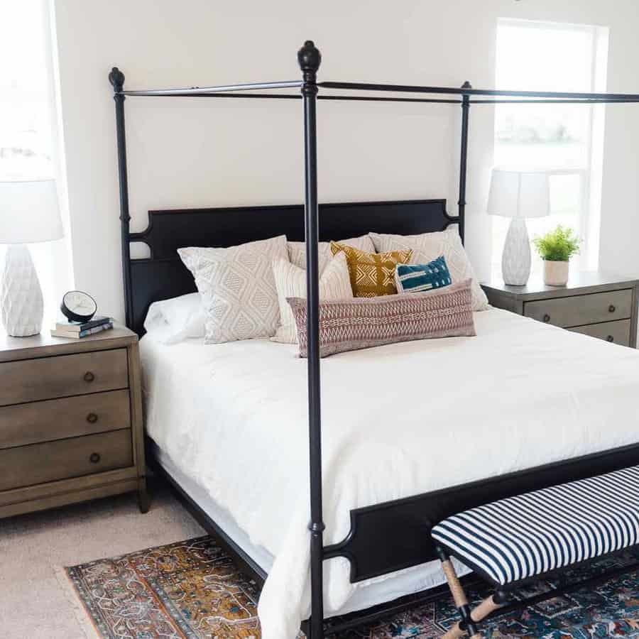 Classic bedroom with black metal canopy bed and patterned rug