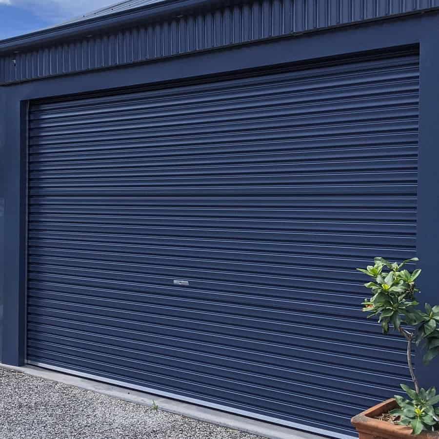 Industrial roll up metal garage door on blue facade