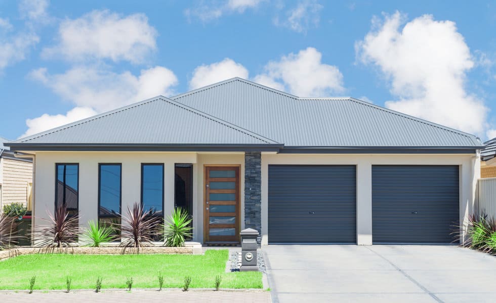 Suburban home with twin dark roller garage doors