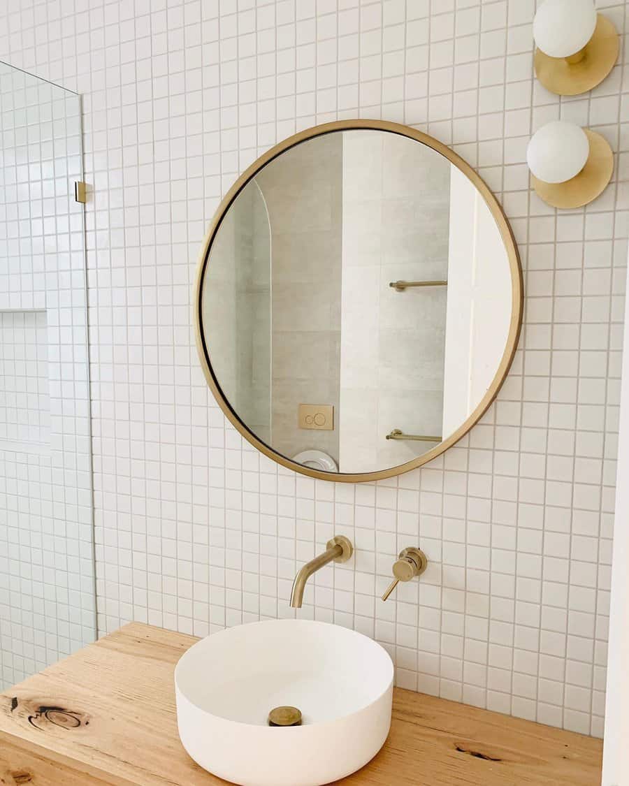 Minimalist bathroom with round mirror and tiled wall