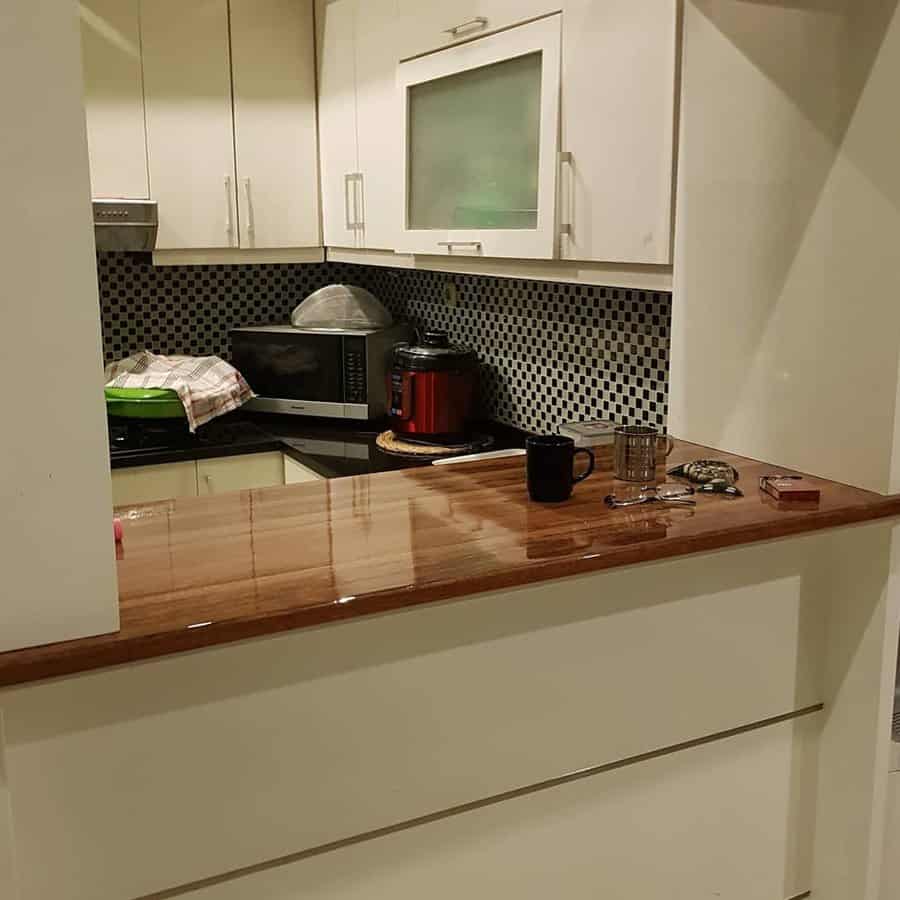 Compact kitchenette with wood counter and mosaic backsplash