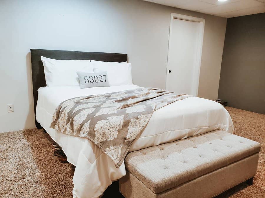 Neutral toned bedroom with patterned throw and bench