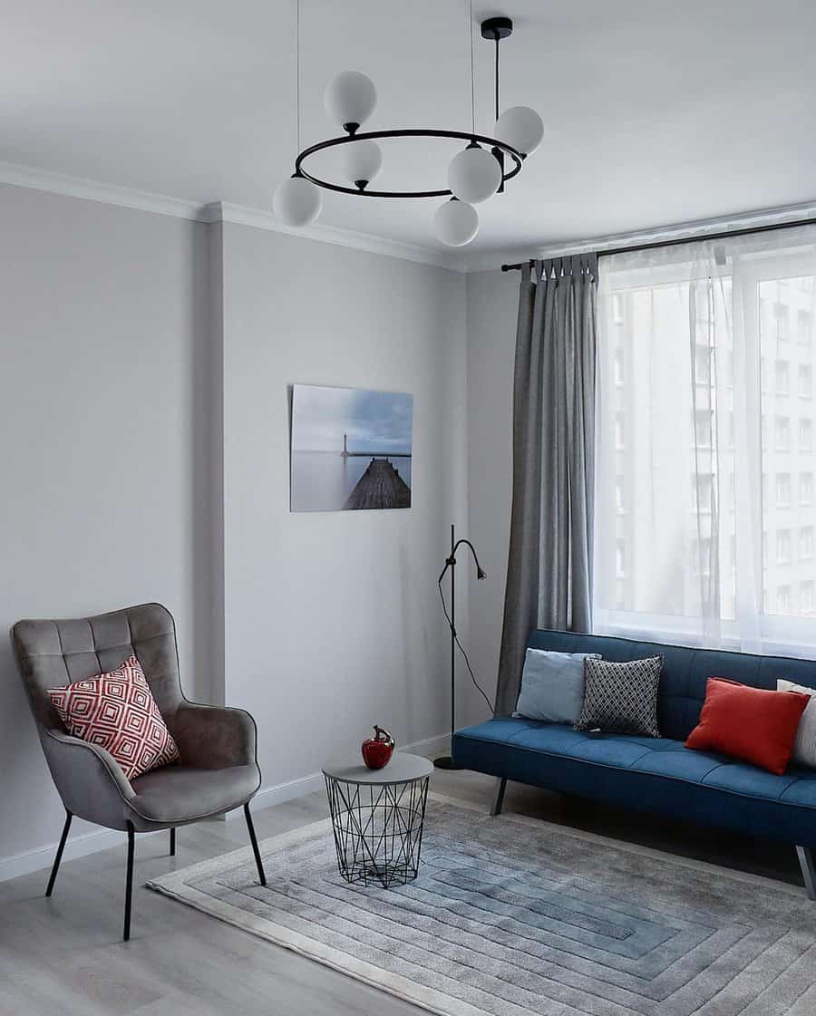 Modern living room with blue sofa and stylish light fixture